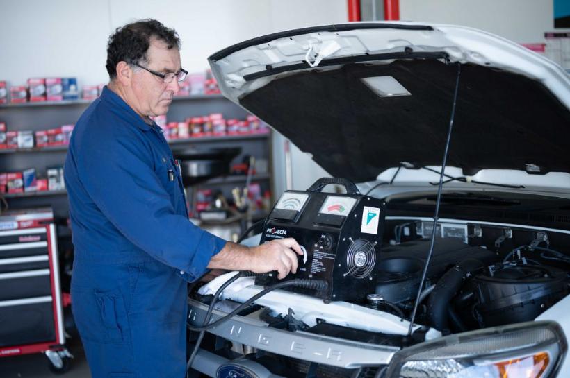 Mechanic working in the engine bay of a 4WD